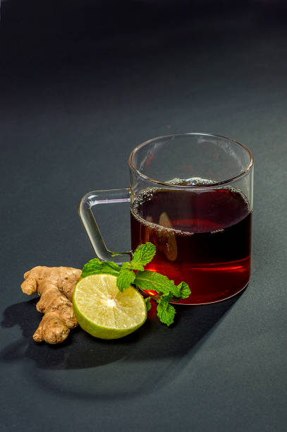 taza de té, menta y limón sobre fondo oscuro - herbal tea fotografías e imágenes de stock
