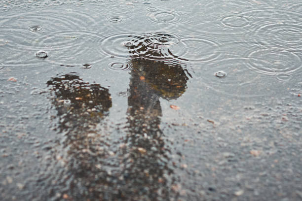 istock Reflection of two rainboots in a puddle at rainy day 1199012819