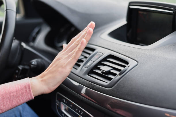 woman hand on air conditioner ventilation grille in the car. climate control panel - air vehicle fotos imagens e fotografias de stock