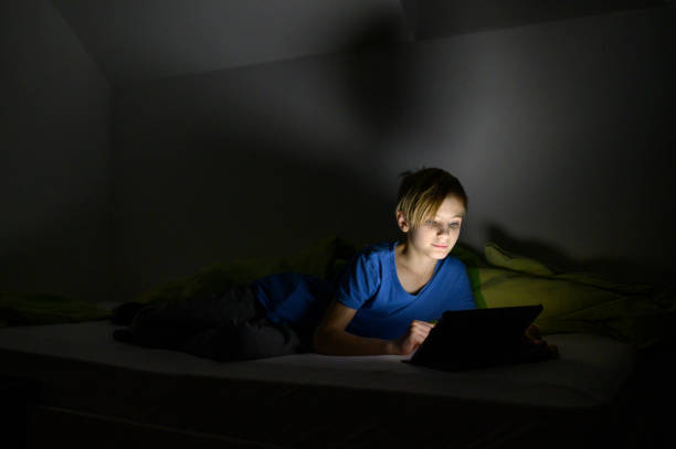 istock Teenage boy using digital tablet at night in the bed 1199013535