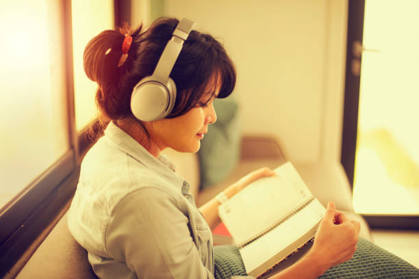 istock Young woman reading at home 1199013633