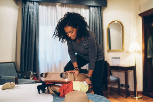 istock Woman struggling with overflowing suitcase 1199016446