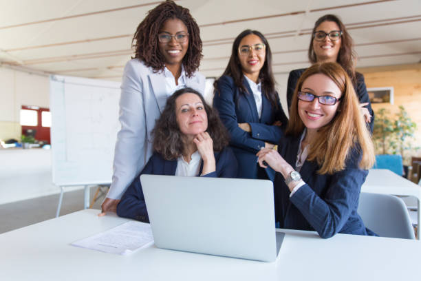 istock Coworkers using laptop and smiling at camera 1199018753