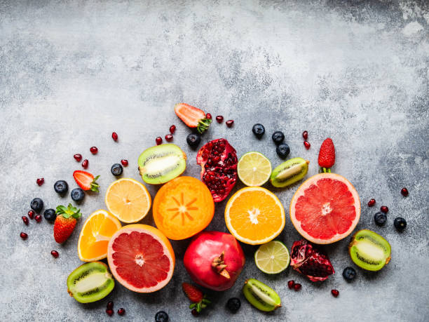 istock Multicolored seasonal healthy natural fruit composition with persimmon, blueberries, orange, kiwi, strawberries, grapefruit, pomegranate, orange slices. Top view 1199020078
