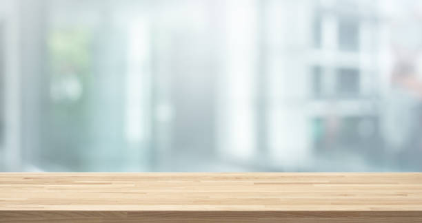 selective focus of wood table top on white wall glass (big window) background - indoors luxury restaurant store imagens e fotografias de stock