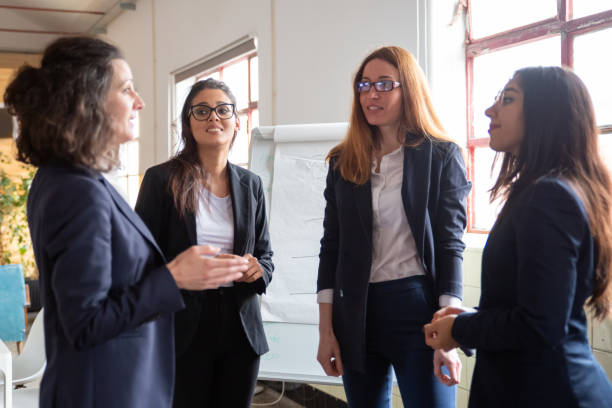 istock Confident mature employee talking with younger workers 1199024103