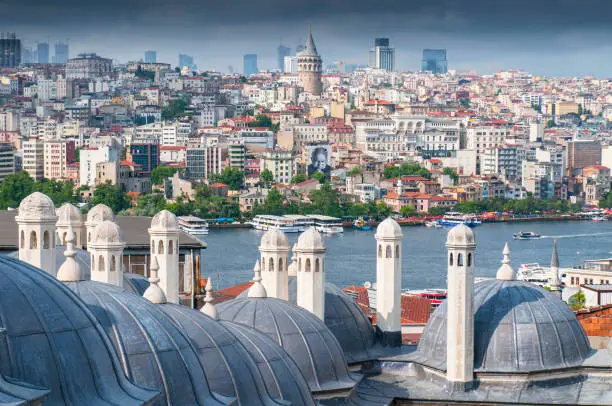 Photo of The domes of Suleymaniye Mosque, with the Bosphorus Strait and Galata Bridge in the distance. Istanbul, Turkey.