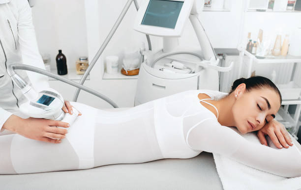 beautician faisant la procédure d'enlèvement de cellulite sur les fesses femelles au salon de spa. la femme veut avoir une très belle figure - cellulite beauty treatment health spa lpg photos et images de collection