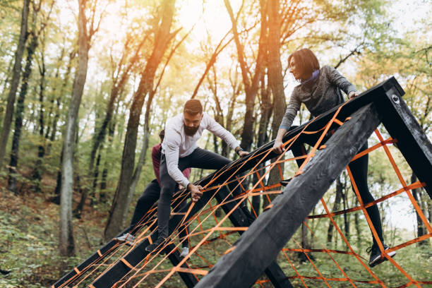 Cross country fitness and training Group of young sporty adult people running and climbing in nature fitness boot camp. fitness boot camp stock pictures, royalty-free photos & images