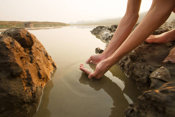 The girl's hand smeared with clay extracts mineral mud from a pit for cosmetic and medical procedures.