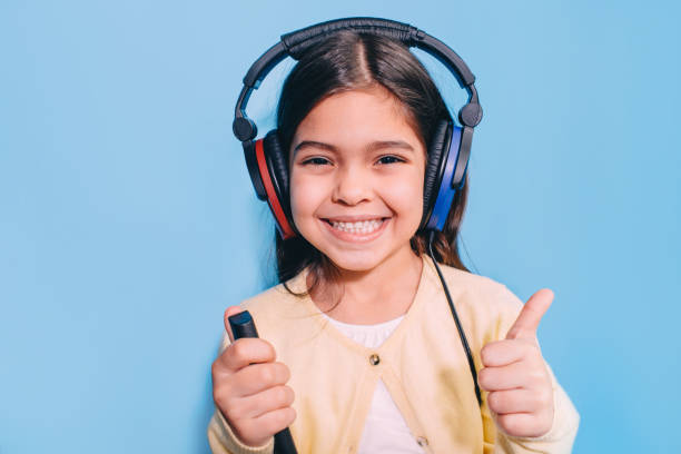 carino bambino di razza mista durante l'esame di procedura. ragazza che indossa cuffie speciali che si alza l'udito, audiometria - esame otorino foto e immagini stock