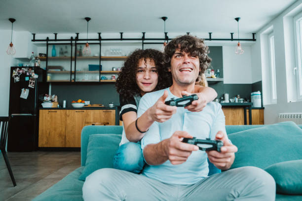 istock Father and son playing digital games at home 1199026084