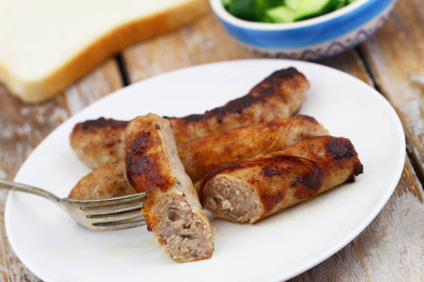 istock Crispy, tasty fried British sausage on fork, closeup 1199026265