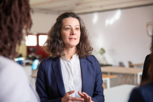 istock Front view of confident mature employee talking with colleagues 1199028701