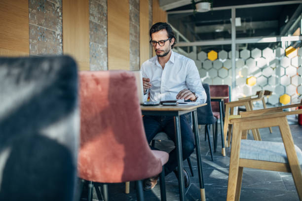 istock Businessman working on laptop in cafe 1199029609