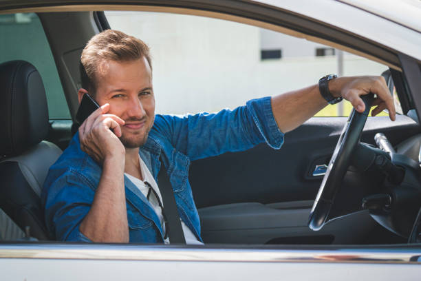 istock Young man inside a car holding a mobile phone. 1199032130