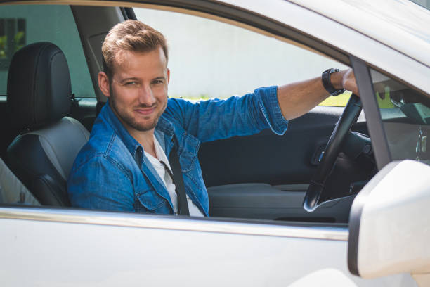 istock Young man driving a car. 1199032243
