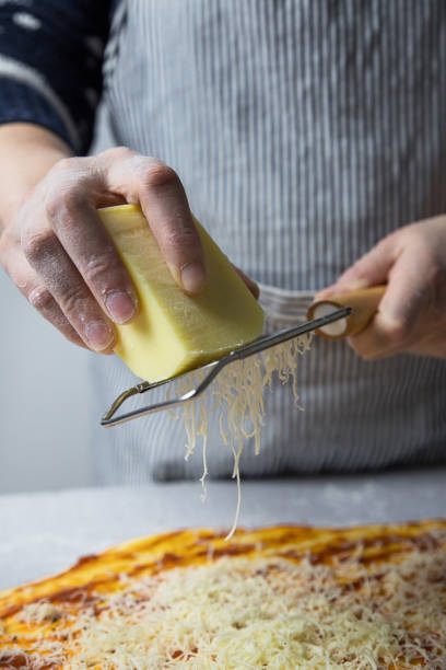 istock Woman Grated Yellow Cheese For Pizza 1199033262