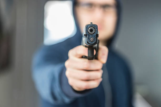 istock Crime or robbery concept: Man with black gun is aiming with his weapon 1199034876