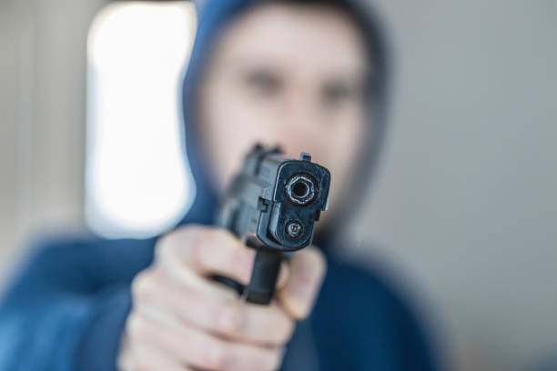 istock Crime or robbery concept: Man with black gun is aiming with his weapon 1199034901