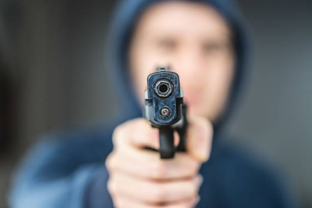 istock Crime or robbery concept: Man with black gun is aiming with his weapon 1199034908