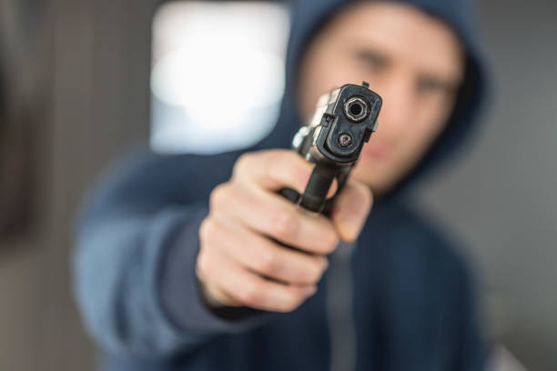 istock Crime or robbery concept: Man with black gun is aiming with his weapon 1199035427