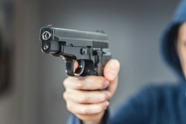 istock Crime or robbery concept: Man with black gun is aiming with his weapon 1199035457