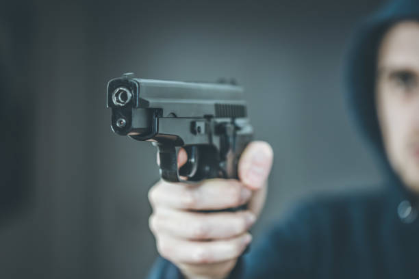 istock Crime or robbery concept: Man with black gun is aiming with his weapon 1199035458