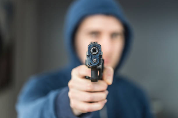 istock Crime or robbery concept: Man with black gun is aiming with his weapon 1199035461