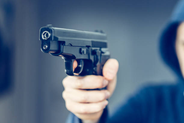 istock Crime or robbery concept: Man with black gun is aiming with his weapon 1199035468