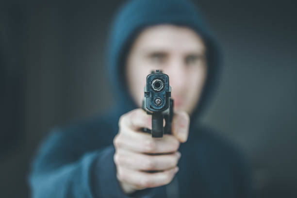 istock Crime or robbery concept: Man with black gun is aiming with his weapon 1199035477