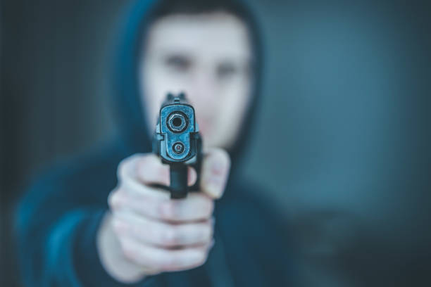 istock Crime or robbery concept: Man with black gun is aiming with his weapon 1199035526