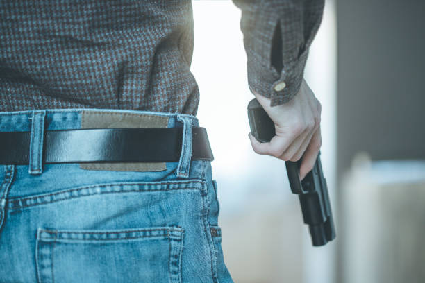 istock Crime or robbery concept: Man with black gun is aiming with his weapon 1199035563