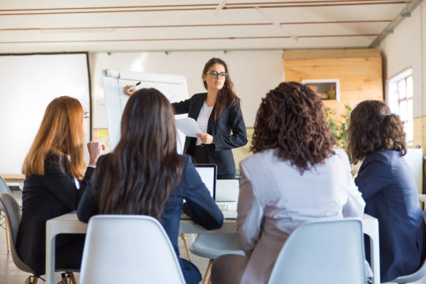 istock Businesswoman writing on whiteboard during presentation 1199035776