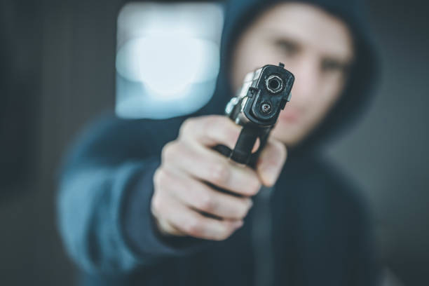 istock Crime or robbery concept: Man with black gun is aiming with his weapon 1199035805