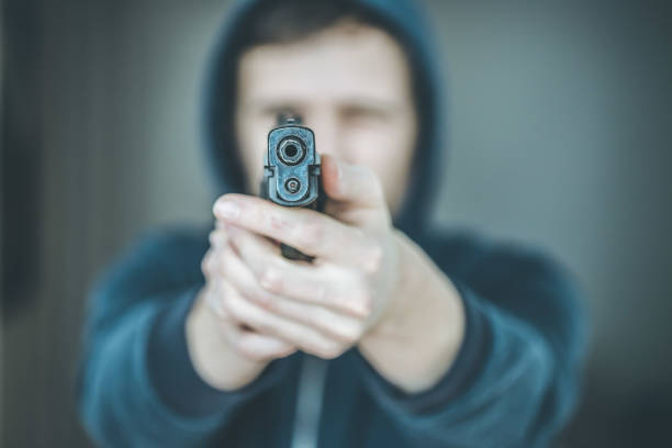 istock Crime or robbery concept: Man with black gun is aiming with his weapon 1199035866