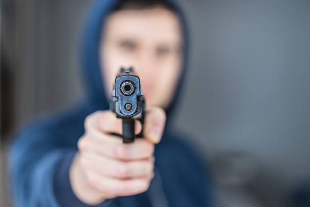 istock Crime or robbery concept: Man with black gun is aiming with his weapon 1199035879