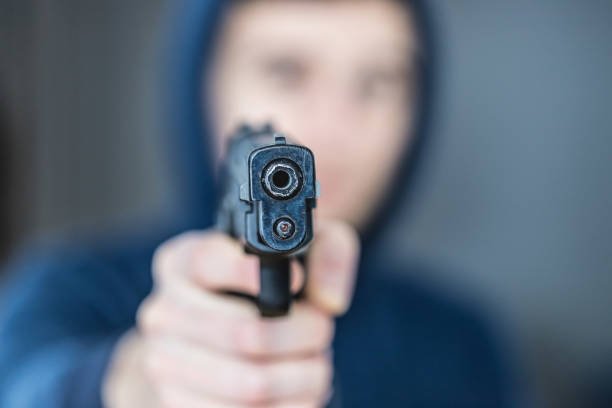 istock Crime or robbery concept: Man with black gun is aiming with his weapon 1199035897