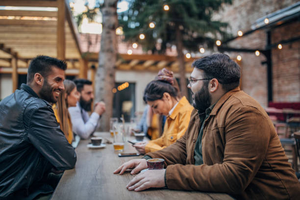istock Group of young joyful friends having fun in a pub 1199036094