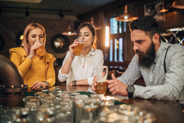 istock Group of young joyful friends having fun in a pub 1199037035