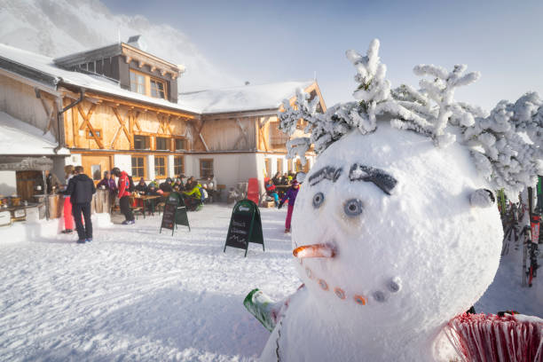 hombre de nieve en la soleada terraza del restaurante hochfeldernalm hut cubierto de nieve saludando a los esquiadores en la estación de esquí de ehrwalder alm, austria, tirol - austria mountain panoramic ehrwald fotografías e imágenes de stock