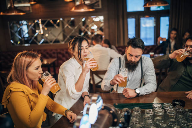 istock Group of young joyful friends having fun in a pub 1199037102