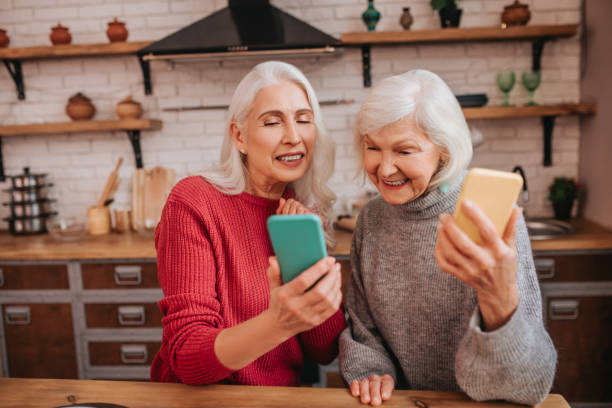 istock Two mature grey-haired positive ladies spending tome online 1199038165
