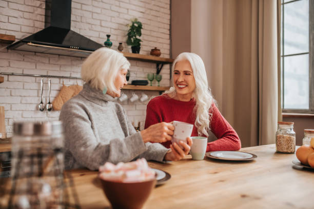 istock Two mature grey-haired positive ladies talking during breakfast 1199038168