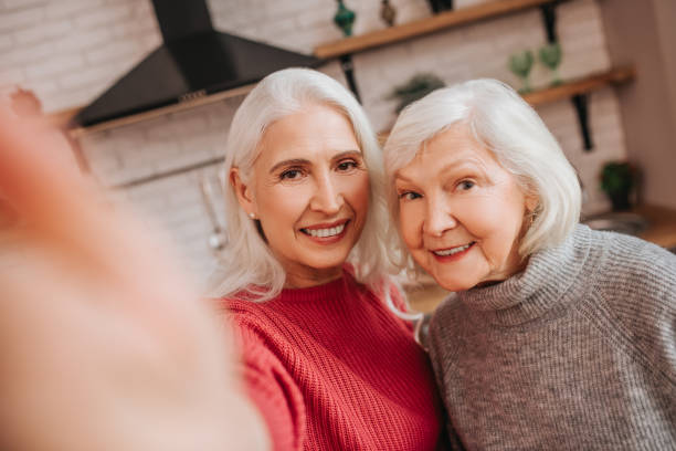 istock Two mature grey-haired positive ladies making selfies 1199038193
