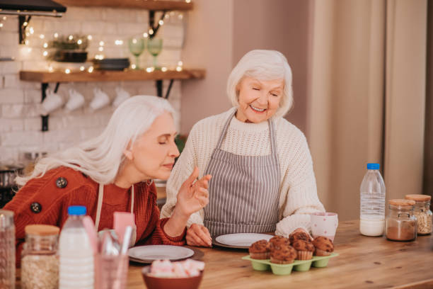 istock Two grey-haired ladies enjoying cooking in the modern kitchen 1199038603