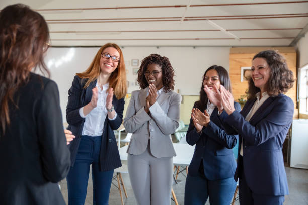 istock Smiling employees applauding colleague 1199040046