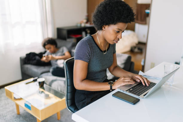 istock Young and beautiful black woman using laptop at home 1199040937