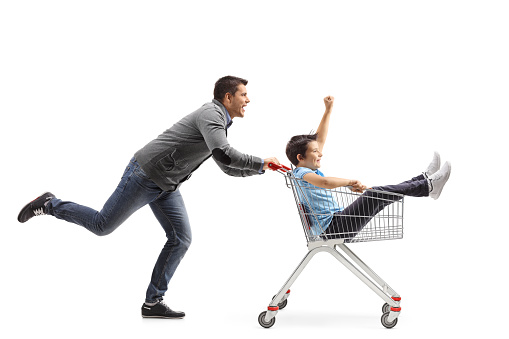 Father pushing son inside a shopping cart isolated on white background
