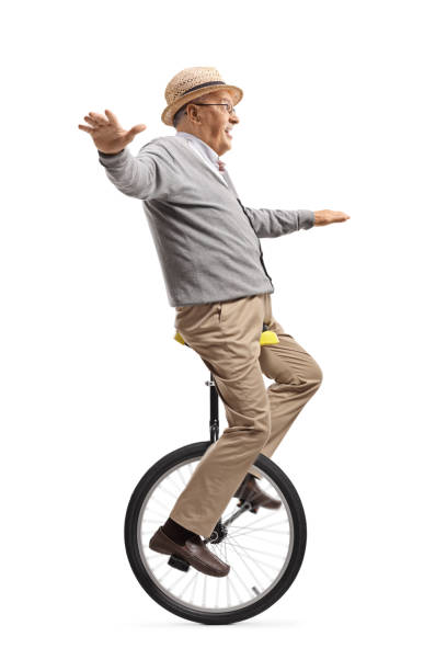 elderly man riding a mono-cycle - unicycle unicycling cycling wheel imagens e fotografias de stock